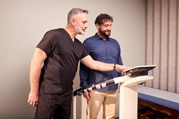 Man standing on scale with health care provider.